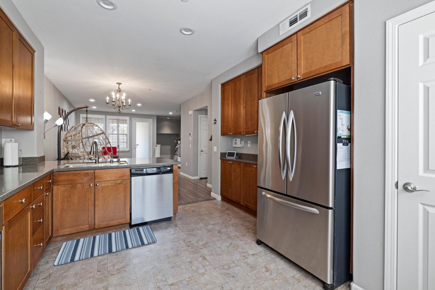 760 Mente Linda Loop Milpitas, CA 95035 - Photo 12 of 24 a kitchen with stainless steel appliances granite countertop a refrigerator a sink dishwasher and a stove with wooden floor
