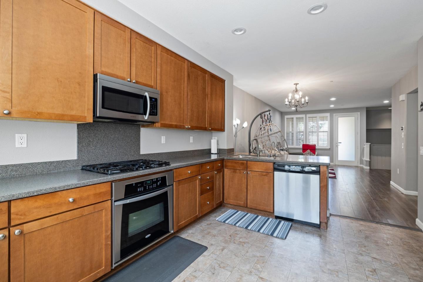 760 Mente Linda Loop Milpitas, CA 95035 - Photo 13 of 24 a kitchen with stainless steel appliances granite countertop a stove top oven a sink dishwasher and a microwave oven on the blue kitchen countertops