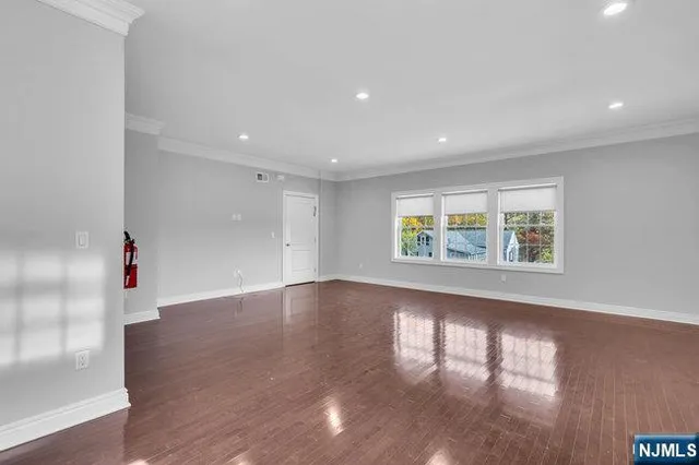 an empty room with wooden floor and window