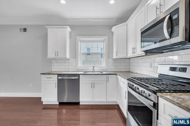 a bathroom with a granite countertop sink a toilet and shower