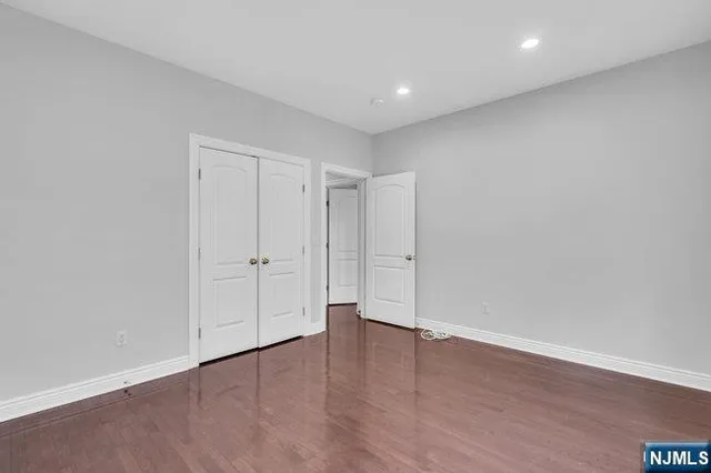 a view of a house next to a big yard and large trees