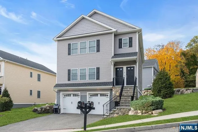 a view of a white house with a big yard and large trees