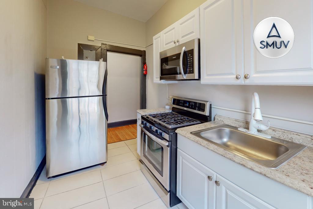 24 East Madison Street, Unit EF Baltimore, MD 21202 - Photo 1 of 23 a kitchen with stainless steel appliances granite countertop a refrigerator a stove a sink and a microwave