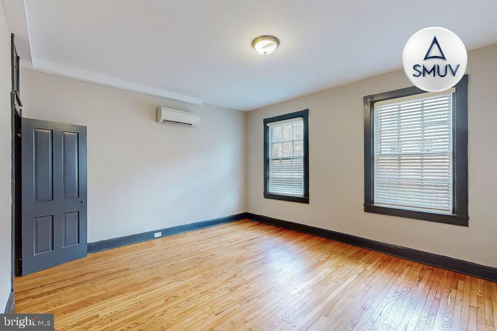 24 East Madison Street, Unit EF Baltimore, MD 21202 - Photo 13 of 23 wooden floor in an empty room with a window