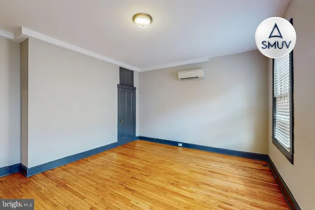 a view of a big room with wooden floor and windows