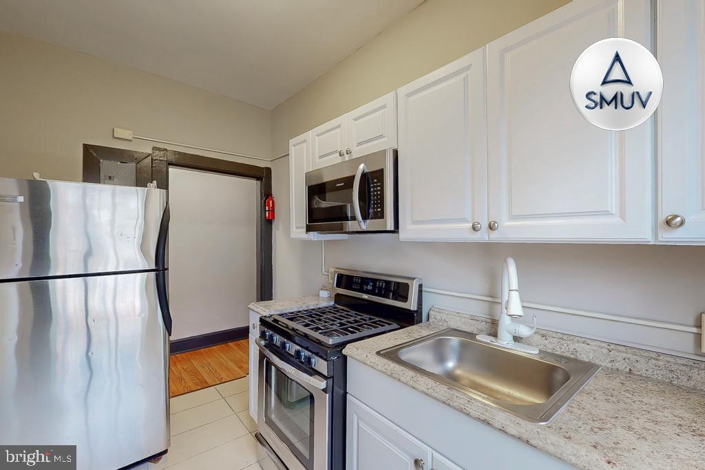 24 East Madison Street, Unit EF Baltimore, MD 21202 - Photo 16 of 23 a kitchen with stainless steel appliances granite countertop a refrigerator a stove a sink and a stove with a refrigerator