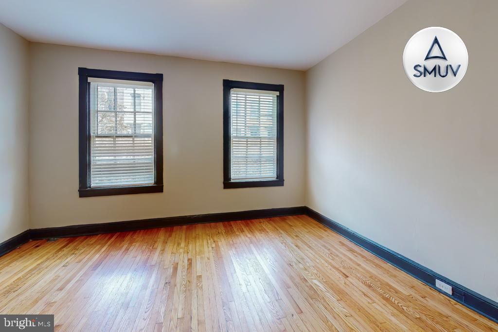 24 East Madison Street, Unit EF Baltimore, MD 21202 - Photo 9 of 23 an empty room with wooden floor and windows