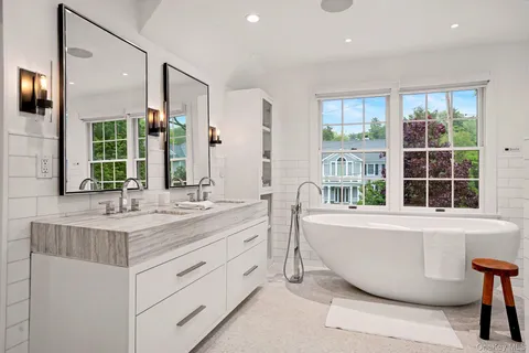 a bathroom with a granite countertop sink mirror and a bathtub