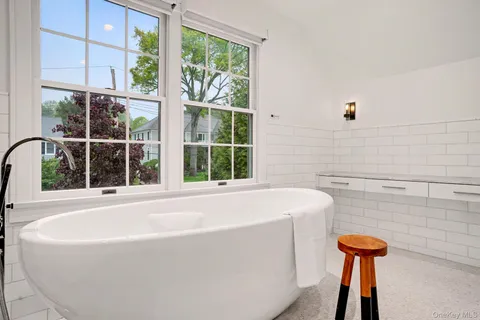 a bathroom with a bathtub and a window
