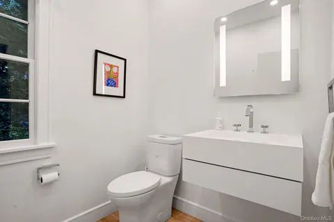 a bathroom with a toilet a sink and mirror