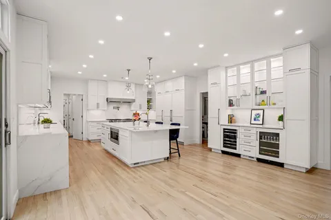 a kitchen with stainless steel appliances kitchen island wooden floors and white cabinets