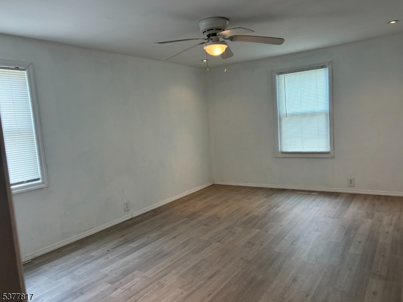 1776 North Tuckahoe Road Williamstown, NJ 08094 - Photo 9 of 16 an empty room with wooden floor chandelier fan and windows
