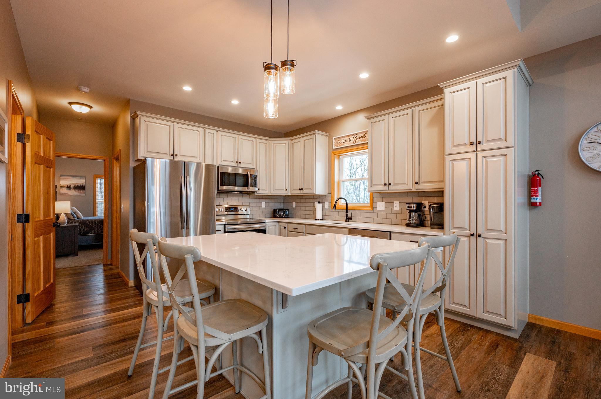226 Wisp Adventure Road McHenry, MD 21541 - Photo 3 of 67 a kitchen with stainless steel appliances a refrigerator a stove a sink dishwasher a dining table and chairs with wooden floor