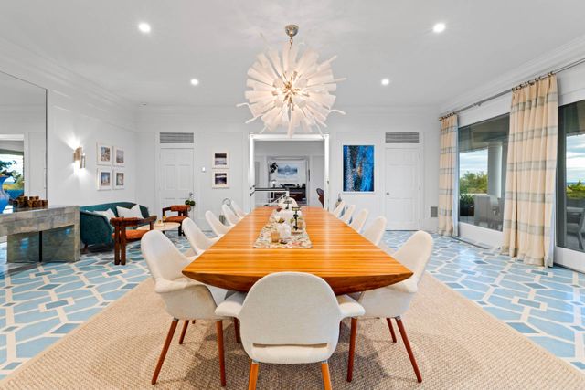 a dining room with wooden floor a chandelier a wooden table and chairs