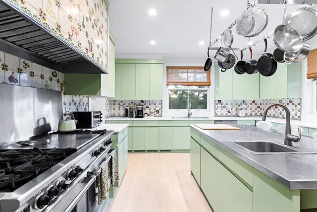 a kitchen with stainless steel appliances granite countertop a sink a stove and a wooden floors