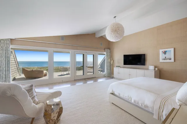 a spacious bedroom with a large bed and a large window