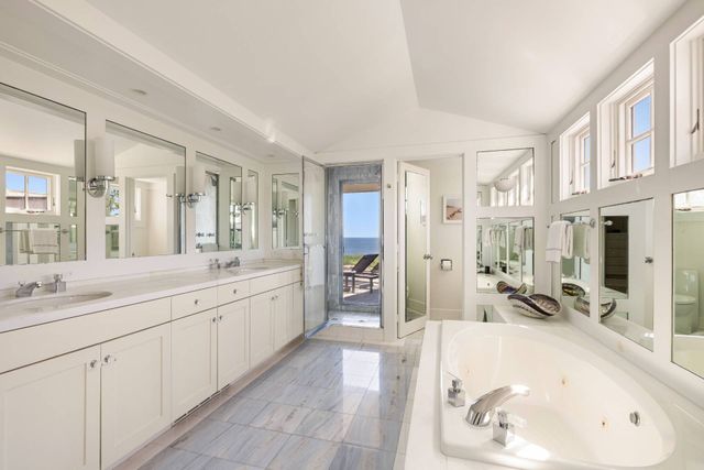 a large bathroom with a tub sink double and mirror