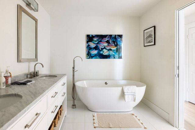 a white bath tub sitting next to a bathroom sink