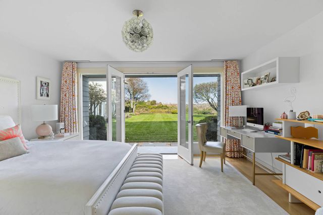 a bedroom with a bed and large windows