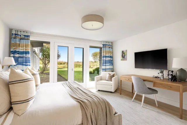 a bedroom with a bed and a flat screen tv