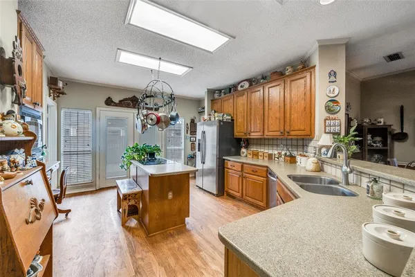 a kitchen with sink refrigerator dining table and chairs