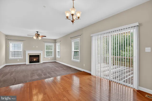 a view of a livingroom with an empty kitchen and a fireplace
