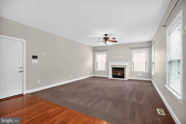 an empty room with windows and fireplace