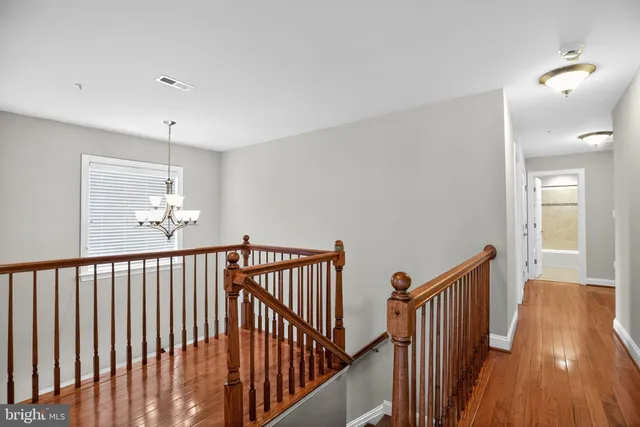 a view of a hallway with wooden floor and stairs