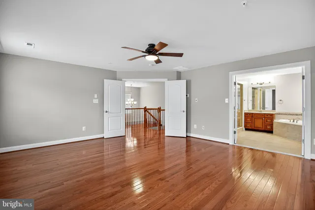 a view of a livingroom with a ceiling fan wooden floor and a ceiling fan