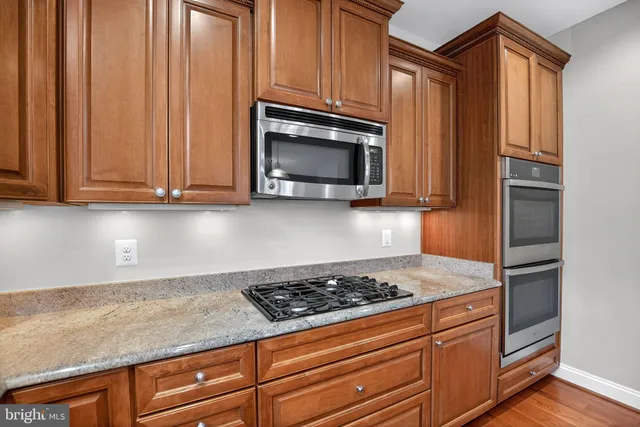 a kitchen with granite countertop cabinets stainless steel appliances and a sink