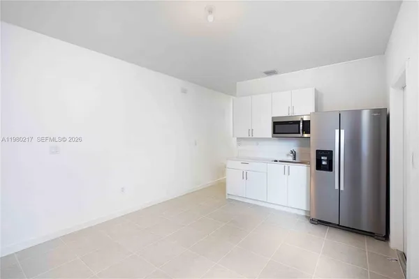 a kitchen with stainless steel appliances a refrigerator sink and microwave