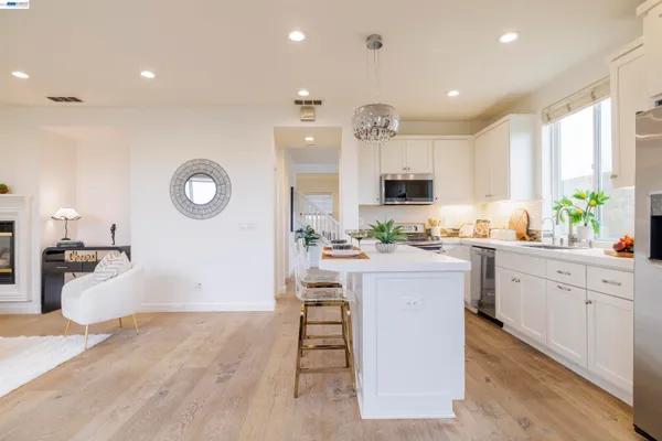 a living room with furniture a large window and a dining table