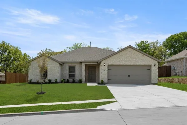 a front view of a house with a garden and yard
