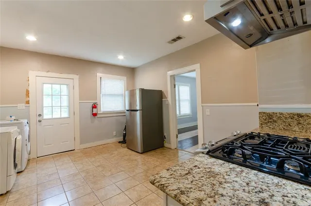 a kitchen with refrigerator and window