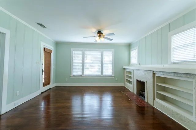 an empty room with windows and a fireplace