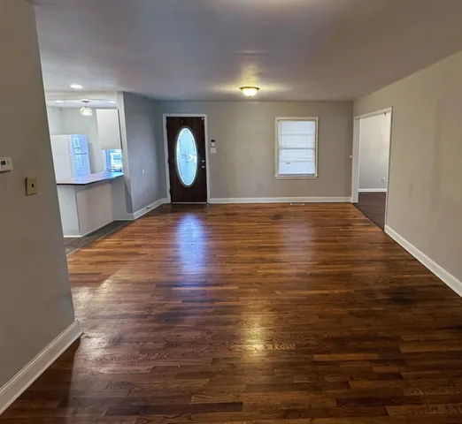 a view of a room with wooden floor and window