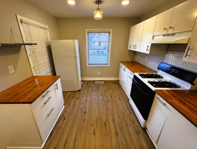 a kitchen with wooden floors and white appliances