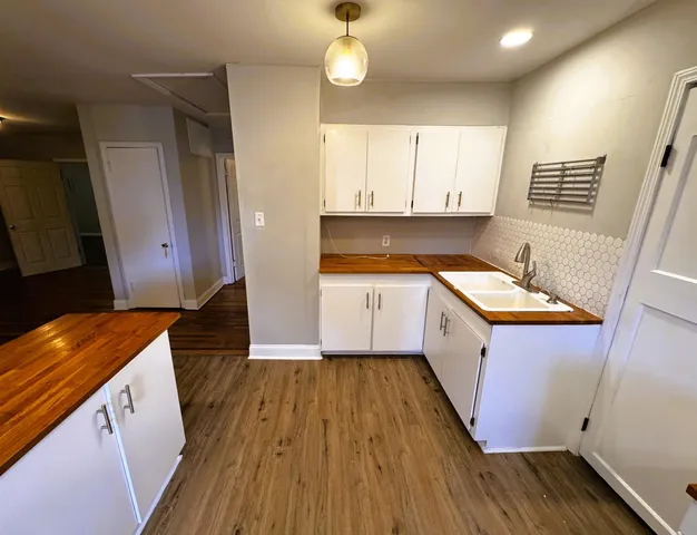 an empty room with wooden floor and stairs
