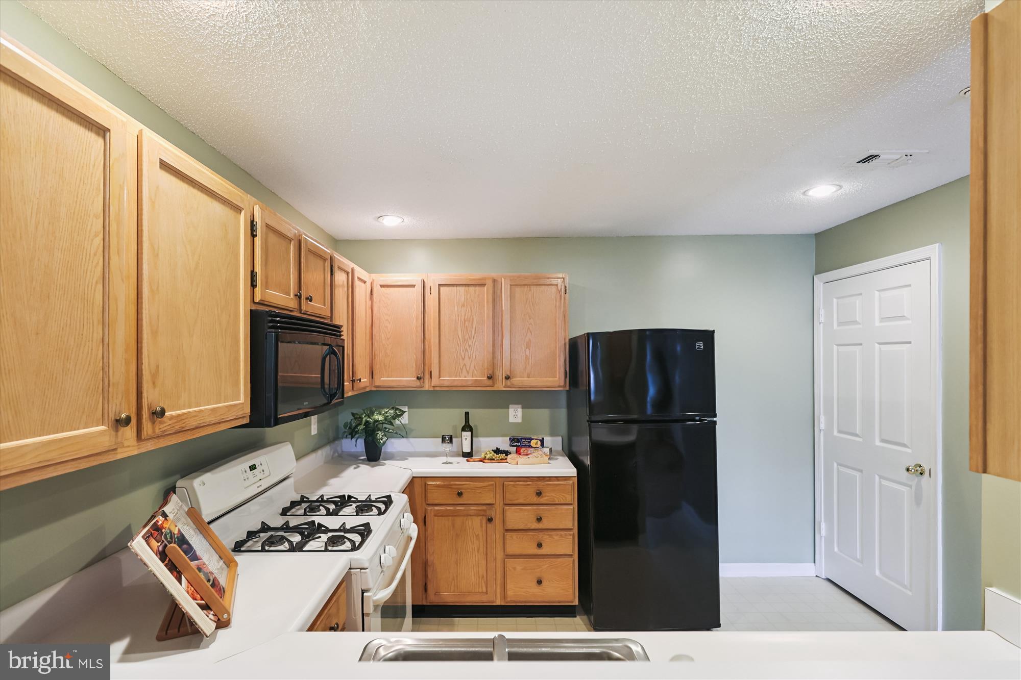12005 Taliesin Place, Unit 35 Reston, VA 20190 - Photo 13 of 39 a kitchen with stainless steel appliances granite countertop a refrigerator and a stove top oven