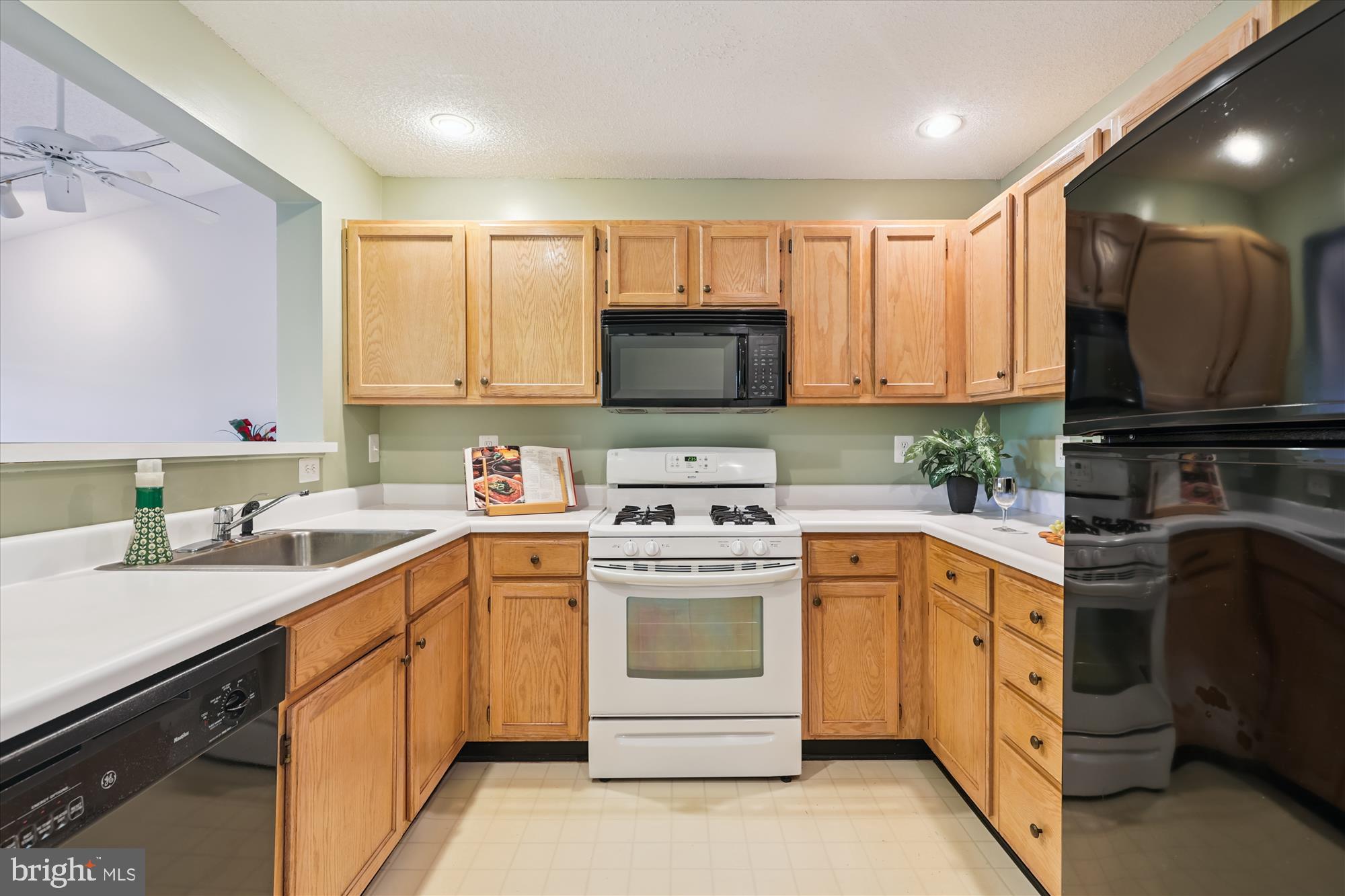 12005 Taliesin Place, Unit 35 Reston, VA 20190 - Photo 10 of 39 a kitchen with white cabinets sink and stainless steel appliances