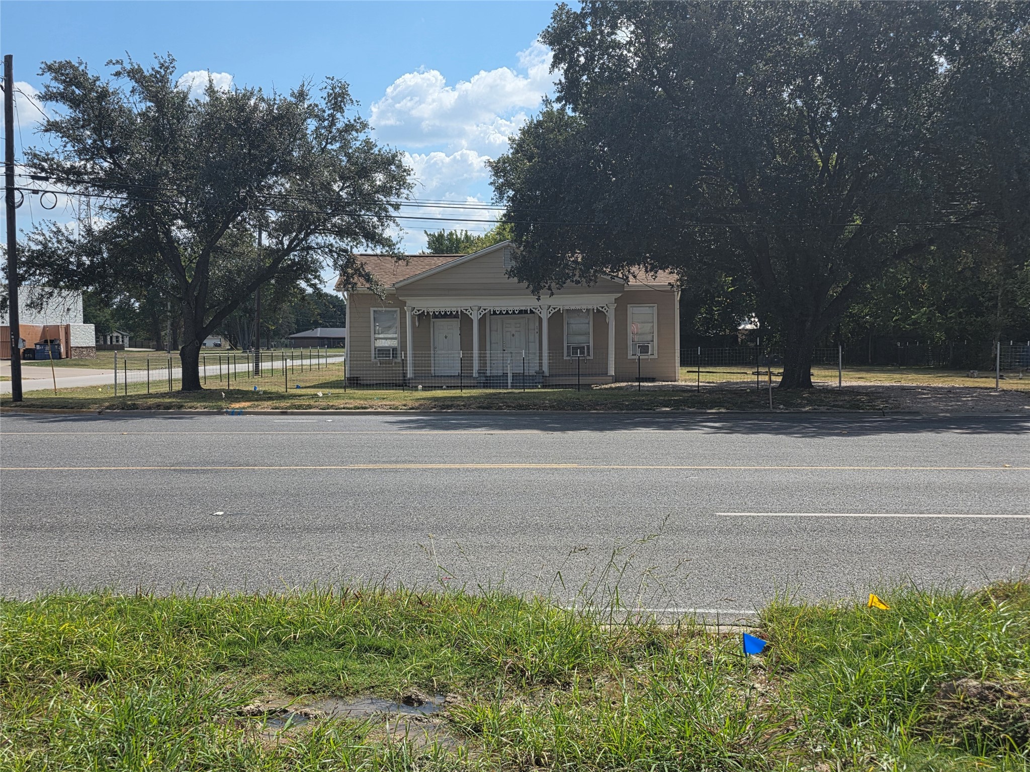 601 East Washington Avenue, Unit A Navasota, TX 77868 - Photo 2 of 17 a front view of a house with a garden and trees