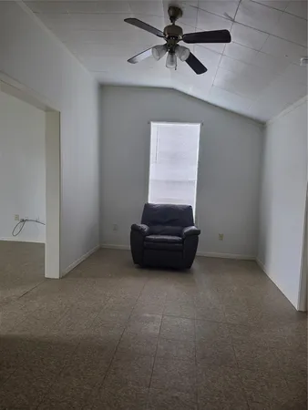 a living room with furniture and a ceiling fan