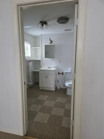 a bathroom with a toilet sink and mirror