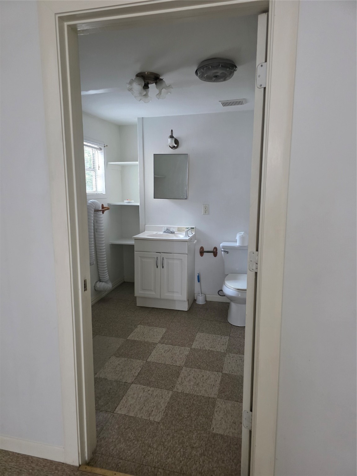 601 East Washington Avenue, Unit A Navasota, TX 77868 - Photo 8 of 17 a bathroom with a toilet sink and mirror