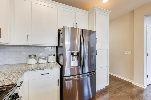 a kitchen with stainless steel appliances granite countertop a refrigerator and a stove