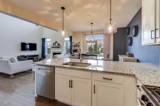 a kitchen with kitchen island granite countertop a sink a counter top space appliances and cabinets