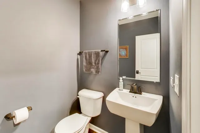 a bathroom with a toilet a sink and mirror