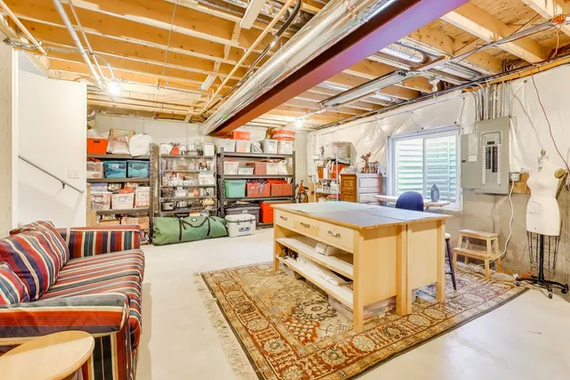 a living room with stainless steel appliances kitchen island granite countertop a table chairs in it and wooden floor