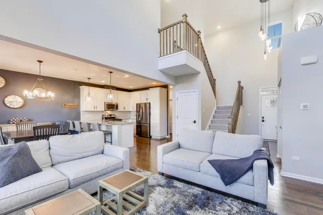 a living room with furniture kitchen view and a chandelier