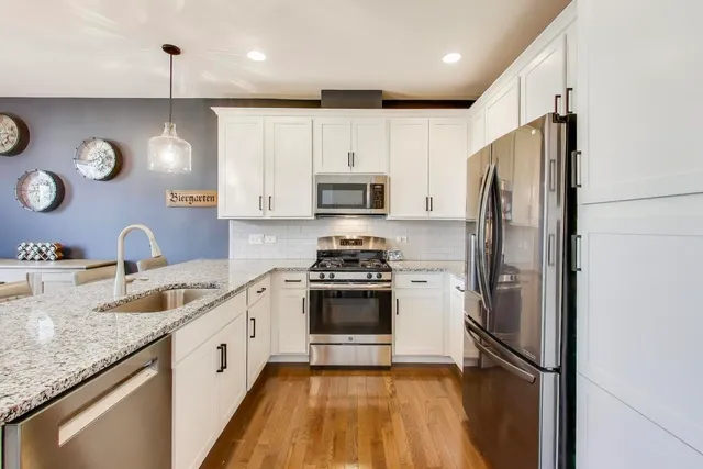 a kitchen with granite countertop stainless steel appliances and a refrigerator